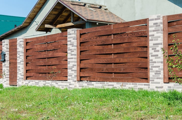 decorative-concrete-fence-with-brick-posts-near-residential-building-with-garden_140282-359